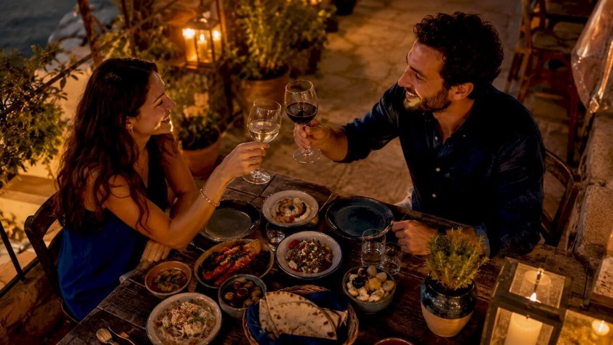 Couple toasting at Mediterranean restaurant table