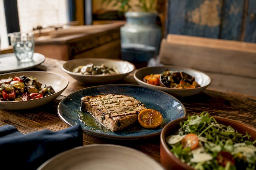 Grilled fish with sides and sauces plated